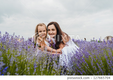 The mother and daughter enjoy the moment in the lavender field The mother and daughter enjoy the moment in the lavender field 127665704