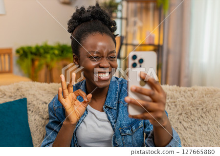 African American happy woman takes selfie with playful smile and poses for social media photos 127665880