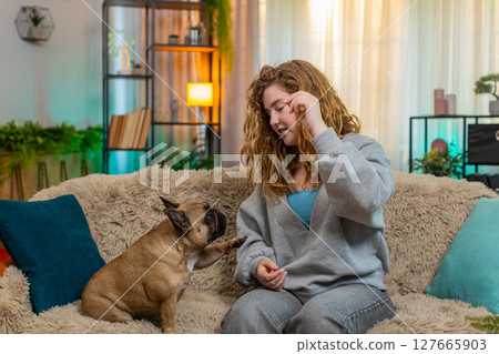 Pug cute dog looking with hope for treat while on home sofa, funny and adorable happy expression 127665903