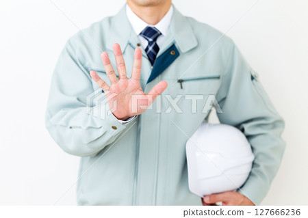 一位身穿綠色工作服的中年男性商人，手拿頭盔，五根手指向上指 127666236