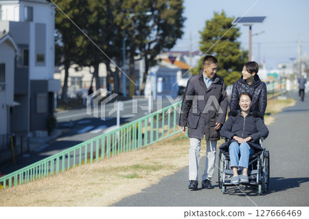 坐輪椅的婦女和家人 坐輪椅的婦女和家人 127666469