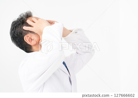 Man in white coat holding head 127666602