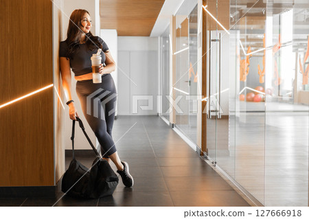 Full length portrait of plus size sporty woman in activewear with gym bag in studio interior Full length portrait of plus size sporty woman in activewear with gym bag in studio interior 127666918