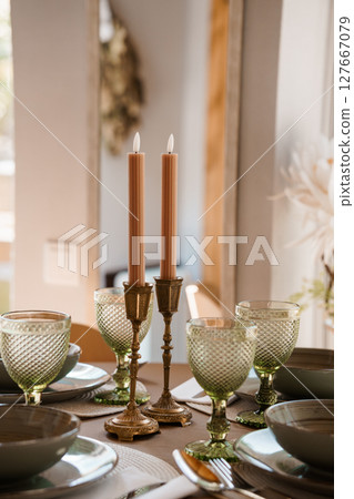 Elegant Table Setting with Peach Candles, Green Glassware, and Antique Brass Holders Rustic Wedding or Dinner Party Atmosphere Elegant Table Setting with Peach Candles, Green Glassware, and Antique Brass Holders Rustic Wedding or Dinner Party Atmosphere 127667079