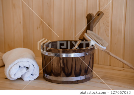 Rustic Sauna Interior with Wooden Bucket, Brush, and Towel: Scandinavian Relaxation Scene with Natural Wood Textures and Warm Color Palette Rustic Sauna Interior with Wooden Bucket, Brush, and Towel: Scandinavian Relaxation Scene with Natural Wood Textures and Warm Color Palette 127667083