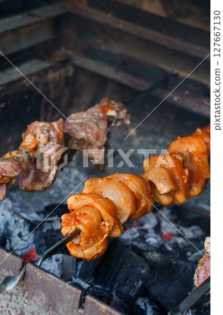 Traditional Argentinian Asado: Rotisserie Grilled Meat Skewers over Charcoal with Rich Smoky Flavors and Rustic Grilling Setup 127667130