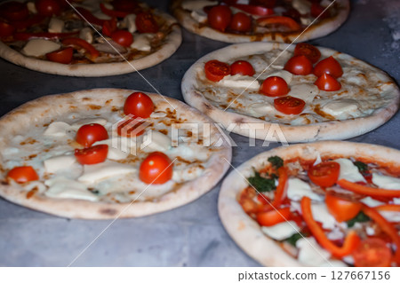 Rustic Mini Pizzas with Cherry Tomatoes, Mozzarella and Chicken on Baking Sheet, Overhead View, Warm Tone Food Photography. Rustic Mini Pizzas with Cherry Tomatoes, Mozzarella and Chicken on Baking Sheet, Overhead View, Warm Tone Food Photography. 127667156