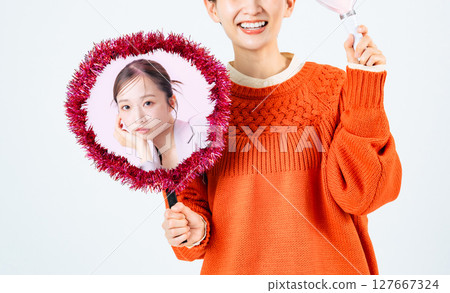 A female fan holding a fan of her favorite idol A female fan holding a fan of her favorite idol 127667324