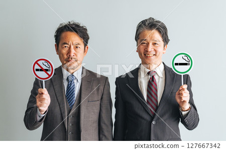 一群中年男性商人舉著吸煙和禁止吸煙的標誌 一群中年男性商人舉著吸煙和禁止吸煙的標誌 127667342
