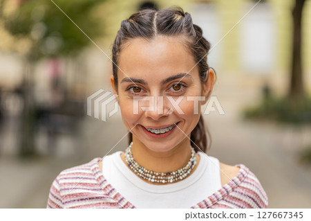 Close up portrait of happy Caucasian young woman showing teeth with braces, smiling, laughing Close up portrait of happy Caucasian young woman showing teeth with braces, smiling, laughing 127667345