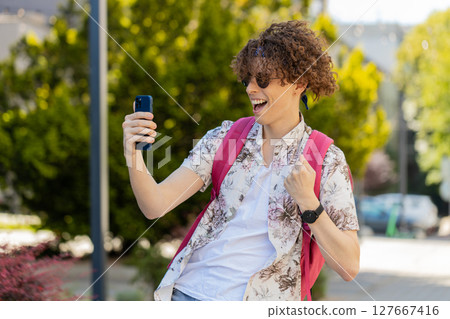 Man using mobile smartphone celebrating win good message news lottery jackpot victory casino app Man using mobile smartphone celebrating win good message news lottery jackpot victory casino app 127667416