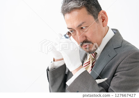 一名男子用放大鏡進行評估 127667427