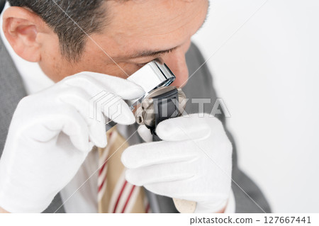 一名男子用放大鏡進行評估 127667441