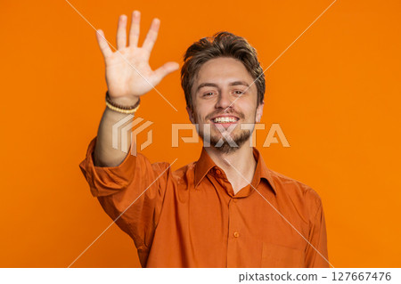 Happy man smiling friendly waving hands gesturing hello greeting or goodbye, meeting invitation Happy man smiling friendly waving hands gesturing hello greeting or goodbye, meeting invitation 127667476