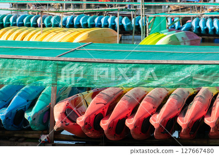 A lot of kayaks placed on wooden frames A lot of kayaks placed on wooden frames 127667480