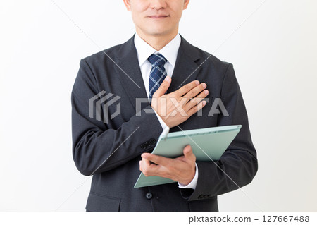 身著西裝、手持活頁夾的中年男性商人 127667488