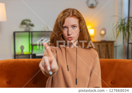 Displeased upset young woman sitting on sofa reacting to unpleasant awful idea, shake finger No Displeased upset young woman sitting on sofa reacting to unpleasant awful idea, shake finger No 127668034