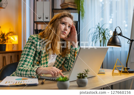 Bored sleepy businesswoman worker working on laptop computer yawns leaning on hand at office desk Bored sleepy businesswoman worker working on laptop computer yawns leaning on hand at office desk 127668156