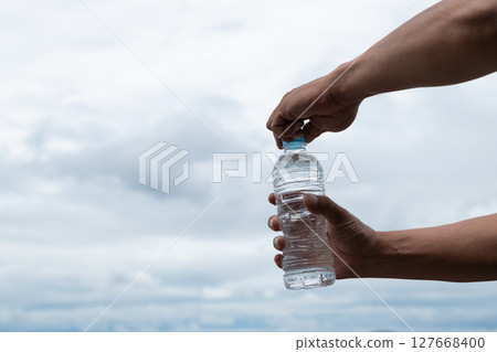 Person holding a bottle of water Person holding a bottle of water 127668400