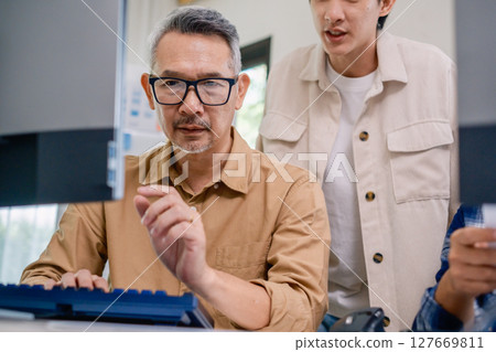 Asian senior bootcamp team asking and  learning programming with software training and whiteboard collaboration 127669811