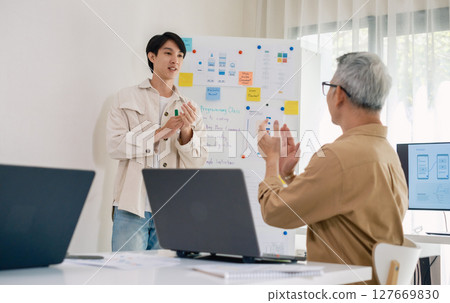 senior programmer bootcamlp,Asian young instructor guides senior learners through a programming on whiteboard, highlighting algorithm thinking and simple code exercises 127669830