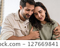 Supportive couple in emotional moment at home as woman struggles with sadness and stress, expressing 127669841