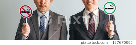 一群中年男性商人舉著吸煙和禁止吸煙的標誌 127670093