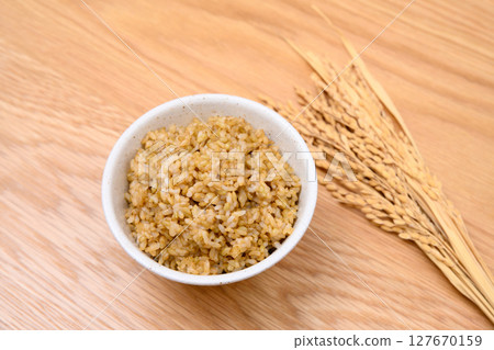 木桌背景上碗裡的糙米和米穗 木桌背景上碗裡的糙米和米穗 127670159