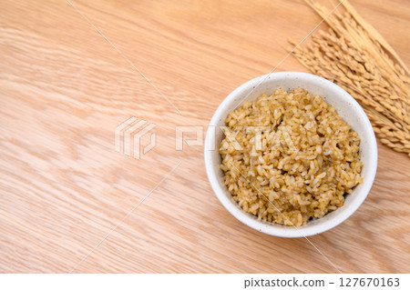 木桌背景上碗裡的糙米和米穗 木桌背景上碗裡的糙米和米穗 127670163