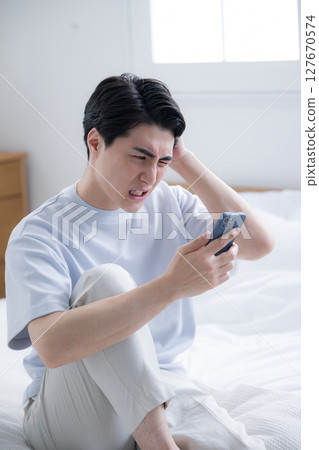 Young man who wakes up to see disturbing emails and chats is shocked, surprised and troubled Young man who wakes up to see disturbing emails and chats is shocked, surprised and troubled 127670574