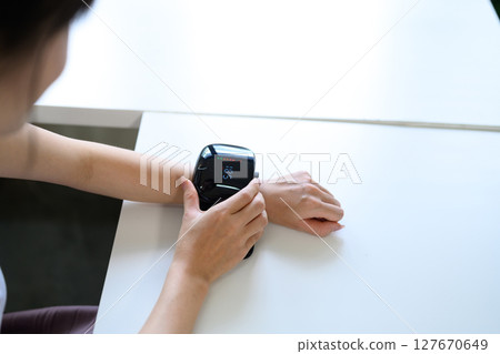 Close up of woman measuring health data with portable wrist monitoring gadget 127670649