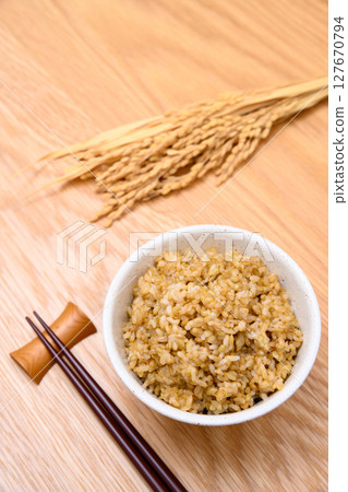 木桌背景上碗裡的糙米和米穗 127670794