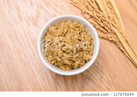 木桌背景上碗裡的糙米和米穗 木桌背景上碗裡的糙米和米穗 127670844