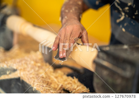 Carpenter working on wood to sanding. 127670978