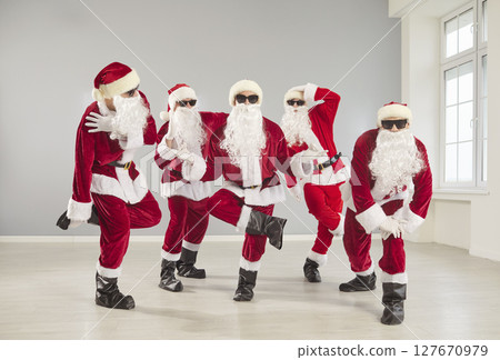 Portrait Of Happy Santas Dancing At Christmas Party 127670979