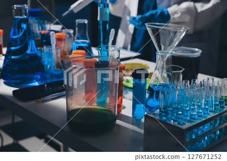 Scientist pipetting medical samples into microplate in laboratory 127671252