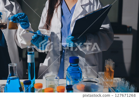 Scientist pipetting medical samples into microplate in laboratory 127671268