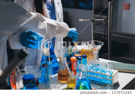 Scientist pipetting medical samples into microplate in laboratory Scientist pipetting medical samples into microplate in laboratory 127671283