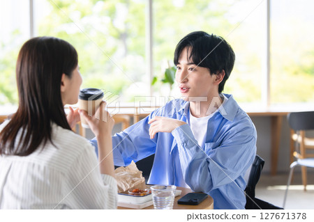 放鬆在咖啡館的年輕人和婦女 127671378