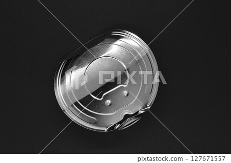Open and folded silver aluminum can lid on black background 127671557