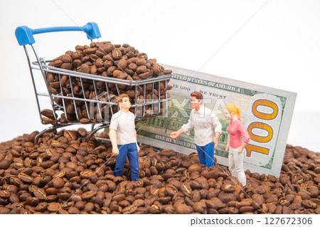 tiny figures standing on coffee beans, a shopping cart overflowing with beans, and a $100 bill 127672306