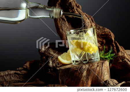 Cocktail gin and tonic with lemon slices and sprig of rosemary. Cocktail gin and tonic with lemon slices and sprig of rosemary. 127672600