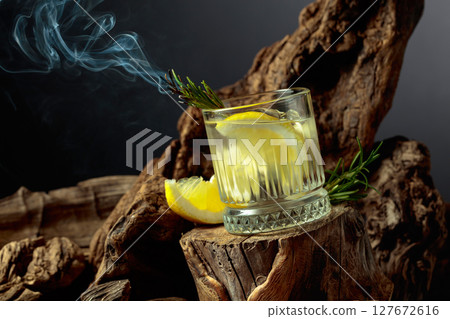 Cocktail gin and tonic with lemon slices and sprig of rosemary. Cocktail gin and tonic with lemon slices and sprig of rosemary. 127672616