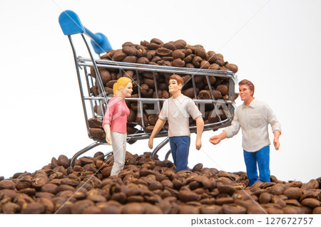 A creative stock photo with miniature figures on coffee beans and a shopping cart A creative stock photo with miniature figures on coffee beans and a shopping cart 127672757