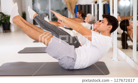 Young boy doing pilates in gym 127672817