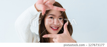 Closeup young Asian woman happy and making frame with fingers Closeup young Asian woman happy and making frame with fingers 127673177