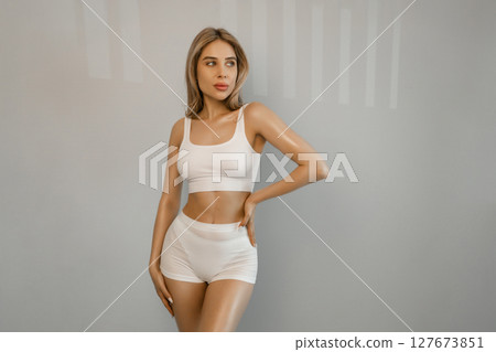 Perfect shape of belly, hips. Beautiful body of young slim woman in white underwear isolated on gray studio background. Wellness, weight loss, treatment, healthcare, fitness concept. Flyer Perfect shape of belly, hips. Beautiful body of young slim woman in white underwear isolated on gray studio background. Wellness, weight loss, treatment, healthcare, fitness concept. Flyer 127673851