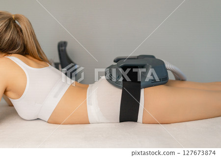 Woman getting treatment on buttocks to burn fat, build muscles and remove cellulite. Professional beauty salon Woman getting treatment on buttocks to burn fat, build muscles and remove cellulite. Professional beauty salon 127673874