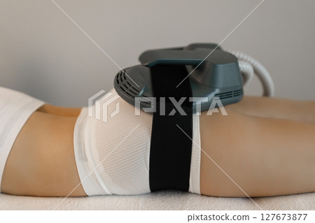 Woman getting treatment on buttocks to burn fat, build muscles and remove cellulite. Professional beauty salon 127673877