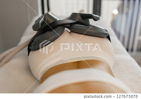 Woman getting treatment on buttocks to burn fat, build muscles and remove cellulite. Professional beauty salon Woman getting treatment on buttocks to burn fat, build muscles and remove cellulite. Professional beauty salon 127673878